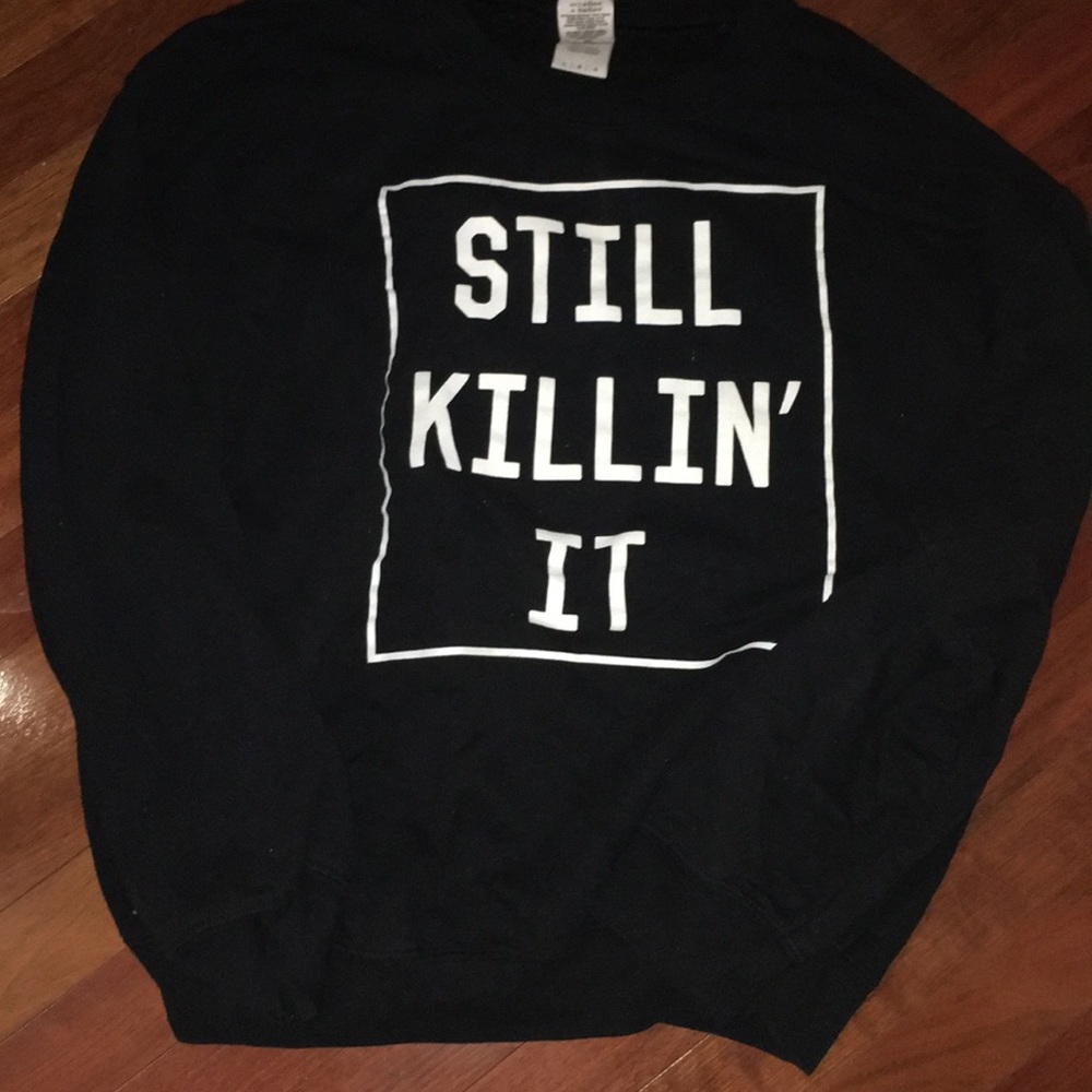 Black crew neck with “STILL KILLIN IT” printed.
